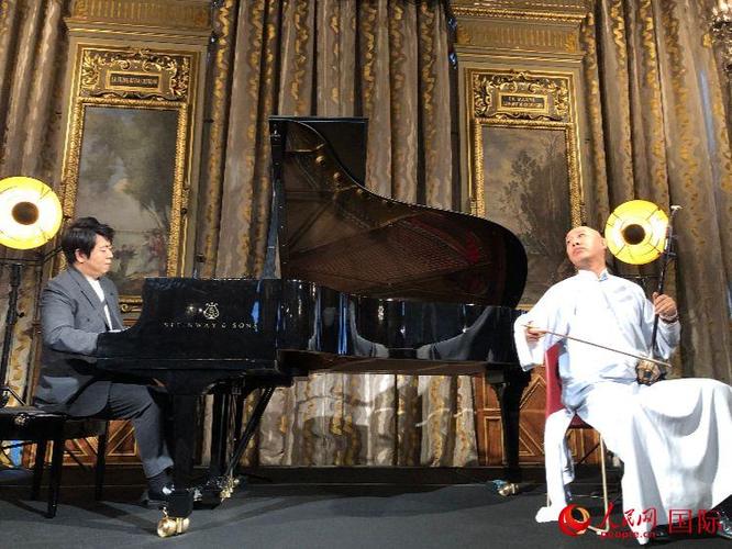 郎朗(左)在发布会上与二胡演奏家果敢合作演奏.人民网记者 刘玲玲摄